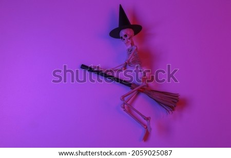 Witch skeleton on a broomstick in gradient neon red-blue light. Halloween theme