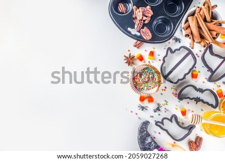 Halloween Gingerbread Cookies cooking background. Autumn holiday baking concept, ingredients, spices, halloween symbol cookie cutters - pumpkin, ghost, bat, witch hat, top view white table copy space