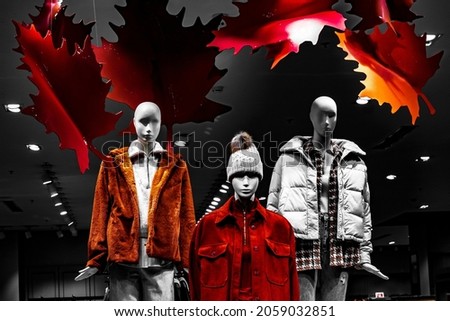 several inanimate plastic mannequins are dressed in autumn and winter clothes; there are no people and recognizable personalities in the photo