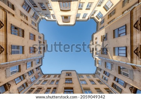 Photo of courtyard in old residential house from historical center of Saint Petersburg, Russia. Clear blue sky. The facade with many windows. Travel destination concept.
