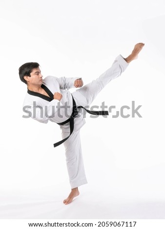 Taekwondo high kick - black belt  taekwondo athlete martial arts master , handsome man show high kick pose during fighter training isolated on white background  Royalty-Free Stock Photo #2059067117