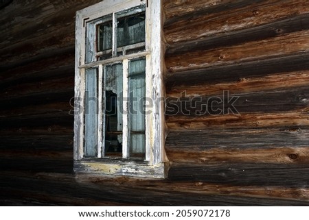 window in a log wall of a village house, night shot in the light of a camera flash