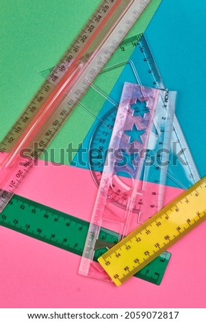 Set of plastic rulers on multicolored background.