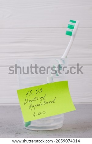 Toothbrush in glass and Dentist Appointment inscription.