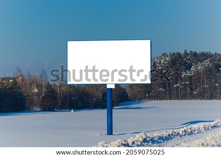 Billboard along the road and highway on a winter snow day. Background for design and advertising. 