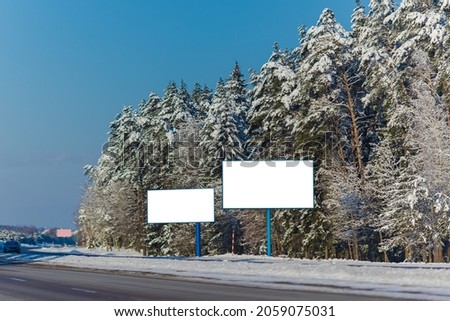 Billboard along the road and highway on a winter snow day. Background for design and advertising. 