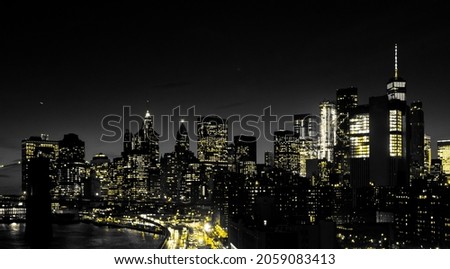 Red lights of Manhattan night skyline shining against a black and white cityscape of downtown New York City NYC