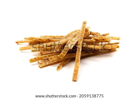 Dried fish sticks isolated. Dry salted seafood snack, hake stockfish, small pieces of dehydrated pollock, beer snacks, dried fish fillet on white background top view