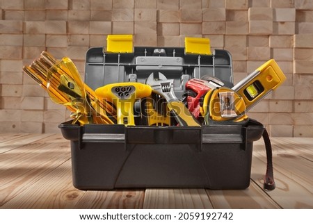 Various Work Tools In Little Black Toolbox. On Background Of Pile Wooden Beams. Royalty-Free Stock Photo #2059192742
