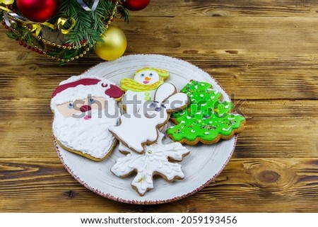 Christmas gingerbread cookies in a plate and Christmas decoration on a wooden table