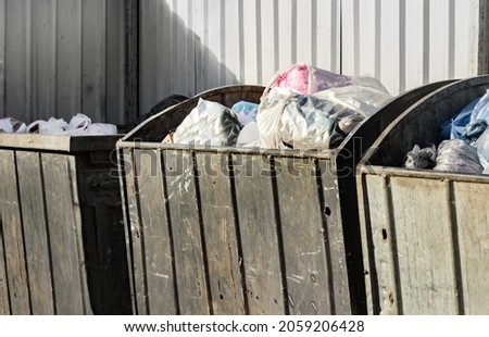 Photo of used and worn metal trash bins with garbade. Royalty-Free Stock Photo #2059206428