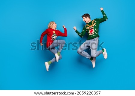 Full length profile photo of hooray young couple jump wear sweater jeans shoes isolated on blue background