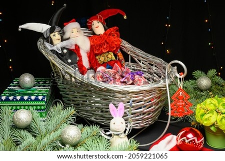Christmas toys in a sleigh, gifts, balls and Santa Claus. Christmas and New Year concept on black background.