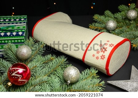 Felt boots with gifts from Santa Claus with fir branches. Christmas and New Year concept on black background.