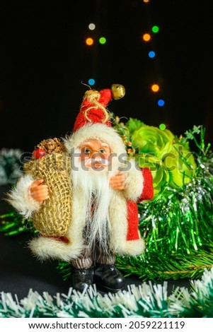 Santa Claus on the background of a pot with flowers. Christmas and New Year concept on black background.