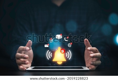 Businessman protecting tablet with virtual yellow bell ringing and icons for application notification alert concept. Royalty-Free Stock Photo #2059228823