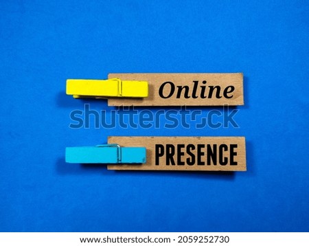 Wooden clips and brown paper with the word online presence on blue background.