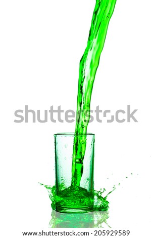 green splashes out drink from glass on a white background.