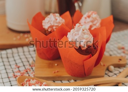 Cupcakes with strawberry cream, wrapped in red paper