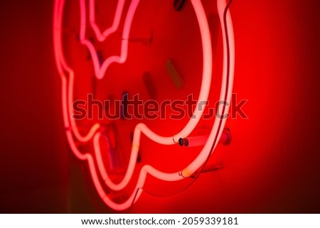 A closeup view of a glowing pink neon sign on a wall.