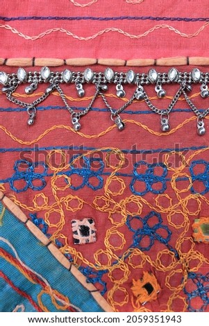 Indian silver anklets on the background of a traditional patchwork carpet. in indian background.