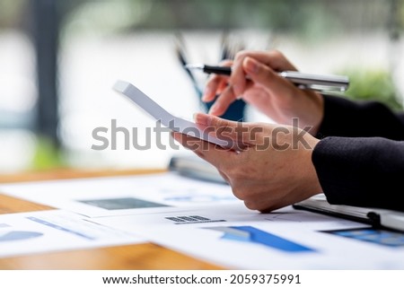 A Businesswoman hand using a calculator with documents financial statistic stock photo,discussion and analysis data the charts and graphs.Market research reports Accounting Finance concept