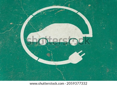 Close-up of electric car charging symbol with green background