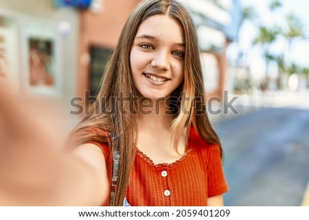 Caucasian teenager girl smiling happy make selfie by the smartphone at the city.