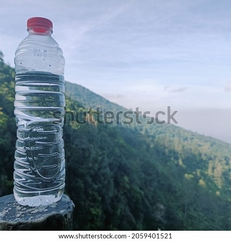 Close up photo of mineral water bottle with blurred natural scenery background.