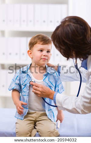 Senior female doctor examining little child boy.