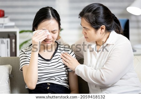 Stressed asian teenager girl crying,life problems with friends at school,disappointed by the love relationships breakup with boyfriend,mother embracing comforting and counselling a sad teenage student Royalty-Free Stock Photo #2059418132