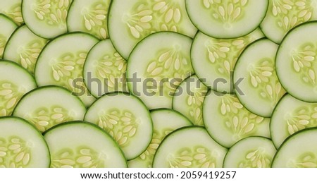 Many round cucumber slices top view. Banner mockup with place for text. Background image with a cutaway vegetable. Picture for packaging design of organic farm food, cosmetics. Copyspece image.