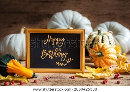 Autumn Pumpkin Decoration With English Text Happy Birthday. Wooden Background with Corlorful Rustic Fall Decor Like Leaf And Golden Picture Frame