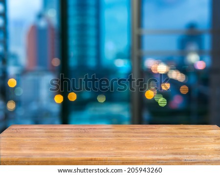 Rustic wood tabletop with abstract blurred modern cityscape night background