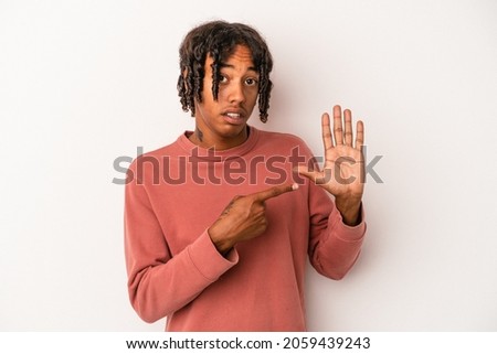 Young african american man isolated on white background smiling cheerful showing number five with fingers.