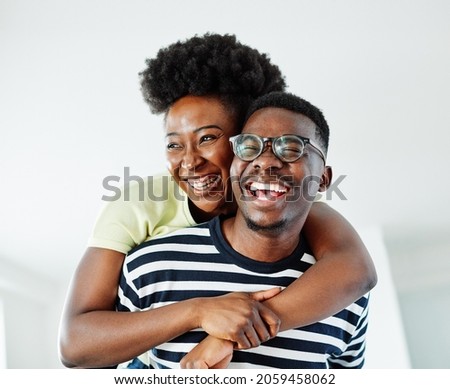 Portrait of a lovely young couple having fun and laughing together piggyback at home Royalty-Free Stock Photo #2059458062