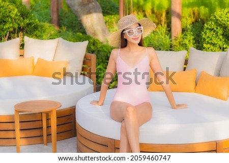 Portrait beautiful young asian woman relax leisure around outdoor swimming pool with sea beach ocean view in vacation travel