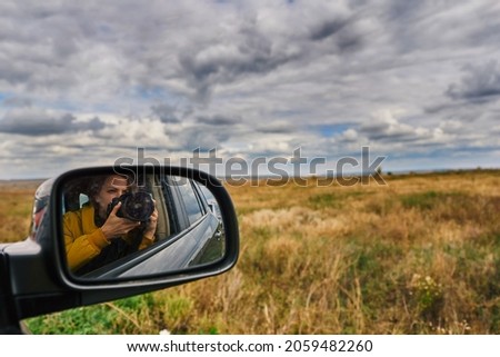 Young woman with camera in autumn road trip.