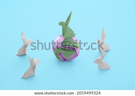Origami rabbits on color background. Concept of uniqueness