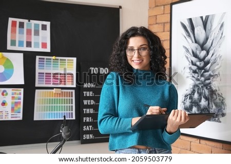 Young female designer working in office Royalty-Free Stock Photo #2059503779