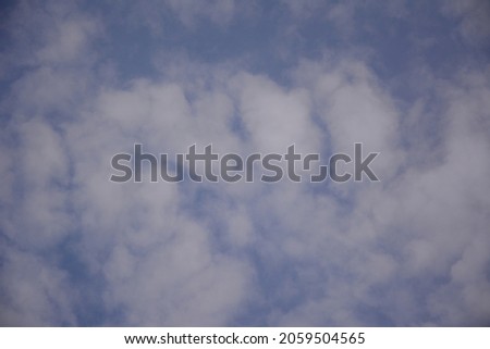 Blue sky with white cumulus clouds. Landscape postcard. Background. Beautiful screensaver.