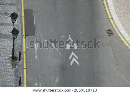 Bicycle Lane White Painted Road Markings with Arrows from High Above with Lamp Posts, Cobblestone Pavements and Yellow No Parking Lines