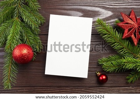 Christmas or New Year greeting card mockup with red festive decorations and fir tree branches