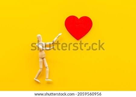 Love emotion concept. Wooden mannequin figure with heart