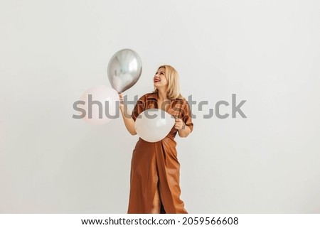 Happy young beautiful blonde woman posing with balloons over white background. Holiday concept, birthday, new year, christmas