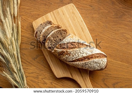 Photography of a fresh bread. close-up. Whole grain bread put on kitchen wood plate or in a crate. Healthy and traditional bakery gold rustic crusty loaves of bread. Vintage box. Selective focus Royalty-Free Stock Photo #2059570910