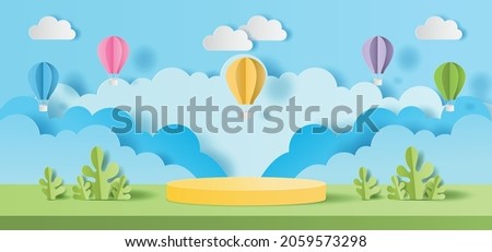 Paper cut of Summer season on green nature landscape, hot air balloons and clouds on blue sky background with yellow color cylinder podium for products display presentation Royalty-Free Stock Photo #2059573298