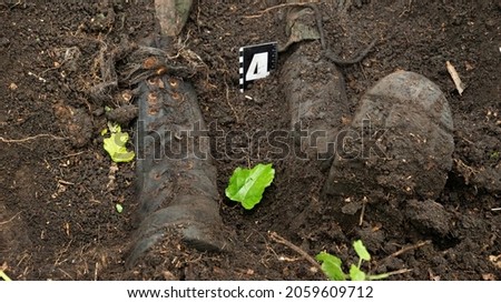 The remains of an unidentified man in military boots were found by the police at the crime scene. With criminological signs that mark evidence Royalty-Free Stock Photo #2059609712