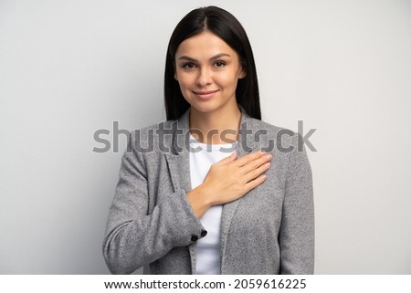 I swear. Portrait of responsible serious businesswoman in business suit holding hand to take oath, promising to be honest, telling truth, pledging allegiance. Studio shot isolated on white background  Royalty-Free Stock Photo #2059616225