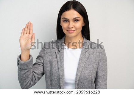 Promise to tell truth. Portrait of woman raising hand to take oaths, promise to speak only truth, be sincere and honest, trustworthy evidence. Studio shot isolated on white background  Royalty-Free Stock Photo #2059616228